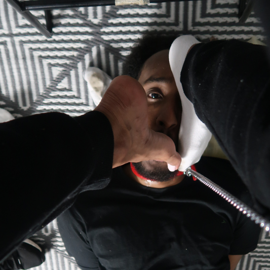 Helpless beneath Goddess Tootsie’s command, he’s forced to sniff and worship her intensely smelly, well-worn socks—no escape, only devotion.