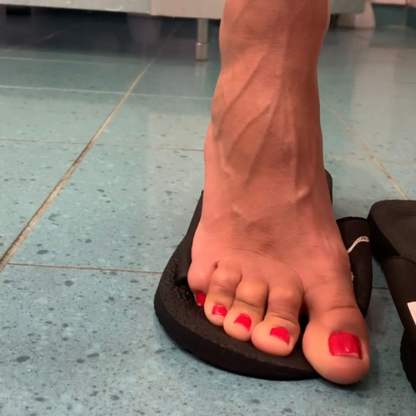 Red-painted toenails in a black flip-flop after a workout
